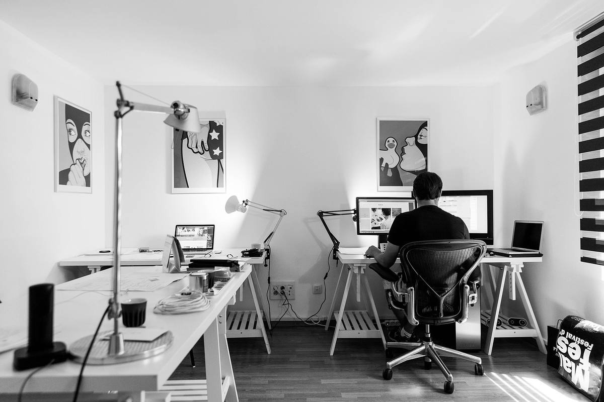 Un homme travaille à son bureau dans un bureau minimaliste Un homme travaille à son bureau dans un bureau minimaliste