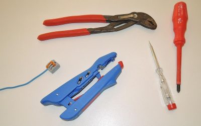 Outils de bricolage et fil bleu sur une surface blanche