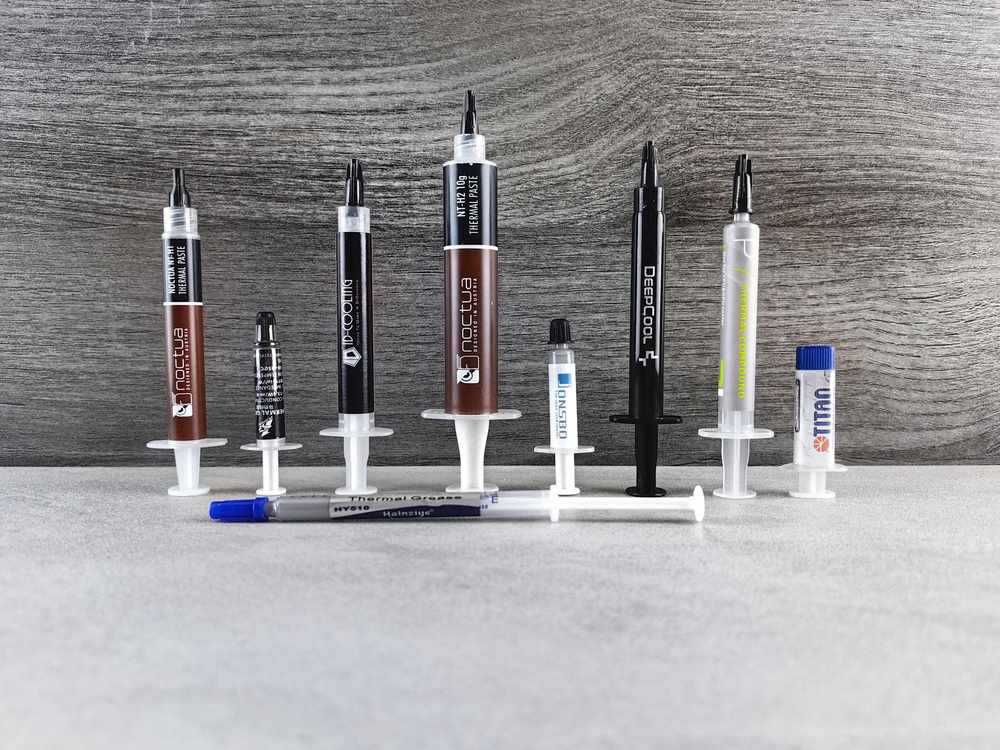 Rangée de tubes de pâte thermique de différentes couleurs et marques alignés
